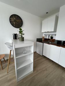 a kitchen with white cabinets and a plant on a shelf at Studio Siana in Chartres