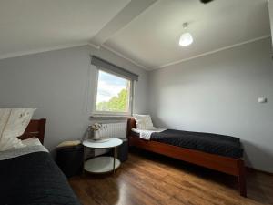 a bedroom with two beds and a window at Milena -Noclegi in Pożrzadło +11 photos