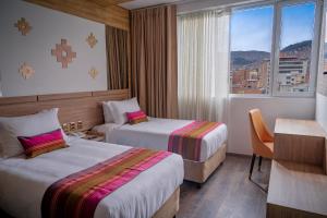 a hotel room with two beds and a window at Illampu Art Boutique Hotel in La Paz