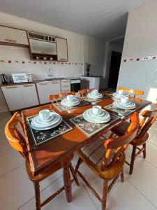a dining room table with chairs and plates on it at Casa Amarela in Penha +34 photos
