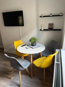 a dining room with a table and yellow chairs at Gemini 1 in Great Wyrley