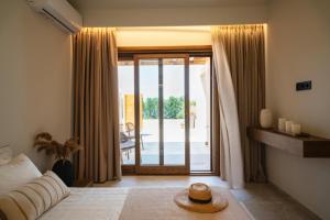 a bedroom with a bed and a sliding glass door at Candelas Suites & Nature in Ierissos