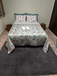 a bedroom with a bed with two slippers on it at Casa Estação da Paz in Miguel Pereira
