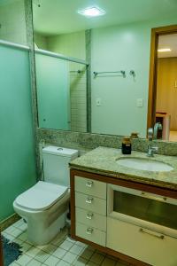 ein Badezimmer mit Toilette, Waschbecken und Spiegel in der Unterkunft Marulhos Resort - Conforto e Espaço pra curtir e relaxar in Porto De Galinhas