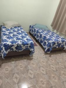 a bedroom with two beds with blue and white covers at Casa Estação da Paz in Miguel Pereira +25 photos