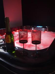 two wine glasses and a bottle on a table at La Loge in Sinceny
