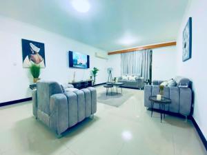 a large living room with couches and tables at Appartement meublé haut standing in Brazzaville