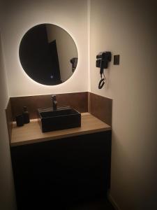 a bathroom with a sink and a mirror at La Loge in Sinceny +5 photos