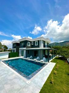 a large house with a swimming pool in front of it at Dalyan villa star 1 in Ortaca