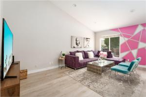 een woonkamer met een paarse bank en een tafel bij Casa Marilyn in Palm Springs