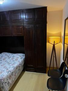 een slaapkamer met een bed, een kast en een stoel bij Apartamento Duplex Cobertura 5 min do centro in Juiz de Fora