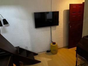 een kamer met een flatscreen-tv aan de muur bij Apartamento Duplex Cobertura 5 min do centro in Juiz de Fora