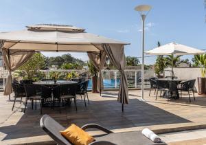 ペネドにあるHotel Terras da Finlândiaのテーブルと椅子と傘のあるパティオ