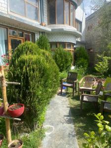 a garden with benches and tables and a building at Muskan Villa in Leh