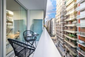 Un balcón con dos sillas y una mesa en un balcón. en Moderno y cálido estudio en Recoleta, en Buenos Aires