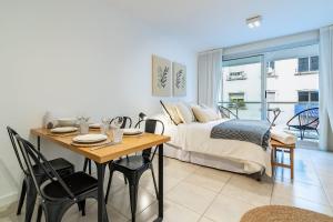 1 dormitorio con 1 cama y 1 mesa con comedor en Moderno y cálido estudio en Recoleta, en Buenos Aires