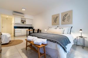 Un dormitorio con una cama grande y una cocina. en Moderno y cálido estudio en Recoleta, en Buenos Aires