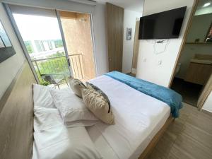 a bedroom with a white bed with a large window at M806- Hermoso y amplio apartamento en Av 19 norte in Armenia