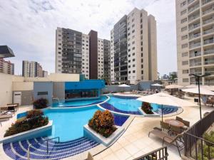an outdoor pool with tables and chairs and buildings at Atrium Thermas Residence Service in Caldas Novas