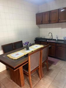 a kitchen with a table with chairs and a sink at Casa com 2 quartos agradáveis com ar condicionado in Foz do Iguaçu