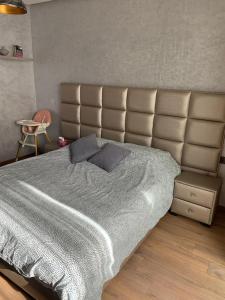ein Schlafzimmer mit einem großen Bett mit großem Kopfteil in der Unterkunft Résidence Hivernage in Agadir