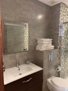 ein Badezimmer mit Waschbecken, Toilette und Spiegel in der Unterkunft Résidence Hivernage in Agadir