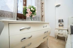 a dresser with a vase of flowers on top of it at PUNTA PRIMA Seaview in Torrevieja