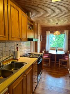 a kitchen with a sink and a stove and a table at Granly in Sandefjord