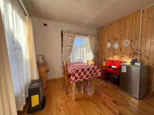 a small kitchen with a table and a refrigerator at Cabaña Kin in La Unión