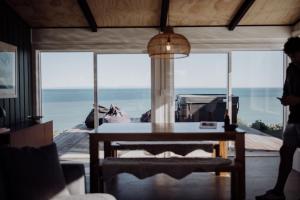 a room with a table and a view of the ocean at Ocean View Bach in Motunau