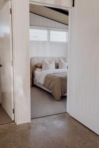 Una puerta de dormitorio con una cama en una habitación. en Ocean View Bach, en Motunau