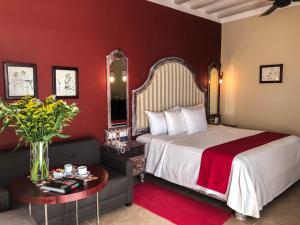 a hotel room with a bed and a couch at Casa Italia Luxury Guest House - Adults Only in M&eacute;rida