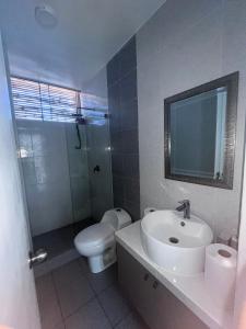 a bathroom with a sink and a toilet and a mirror at Casa Tres Ventanas de Azpitia in Santa Cruz de Flores +22 photos
