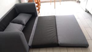 a large black couch sitting in a room at Apartamento cerca del Mar in Empuriabrava