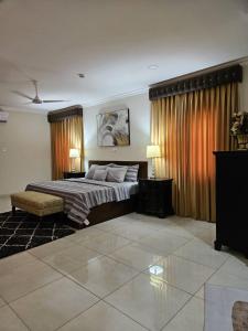 a bedroom with a bed and two tables and two lamps at Summit Residence in Accra