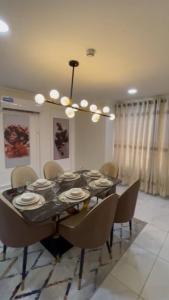 a dining room table with chairs and a chandelier at Summit Residence in Accra