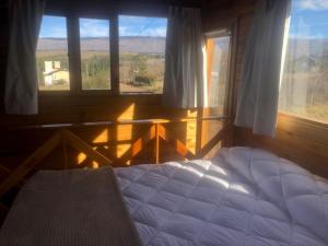 a bedroom with a bed and a window with a view at Cabaña Snowflakes in Villa Yacanto