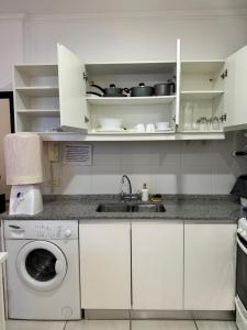 a kitchen with a sink and a washing machine at 4hermanos in Rufino +5 photos