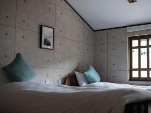 سرير أو أسرّة في غرفة في Machiya Hotel oyado baison