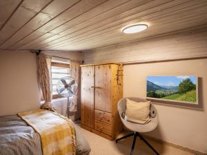 a bedroom with a bed and a fan and a chair at Teresa II Dachgeschosswohnung mit 2 Schlafzimmern - by NV-Appartements in Kirchberg in Tirol