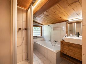 a bathroom with a tub and a sink at Teresa II Dachgeschosswohnung mit 2 Schlafzimmern - by NV-Appartements in Kirchberg in Tirol