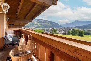 a balcony with a table and chairs and mountains at Teresa II Dachgeschosswohnung mit 2 Schlafzimmern - by NV-Appartements in Kirchberg in Tirol