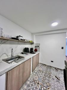 une cuisine avec un évier et un plan de travail dans l'établissement aparta estudio de lujo, à Pasto 1 autre photo