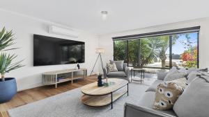 un soggiorno con un divano e una TV di Little Boat Beach House at Aldinga Beach by Wine Coast Holiday Rentals a Aldinga Beach