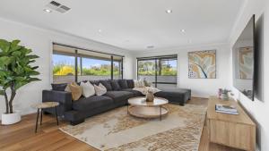 un soggiorno con un divano e un tavolo di Little Boat Beach House at Aldinga Beach by Wine Coast Holiday Rentals a Aldinga Beach