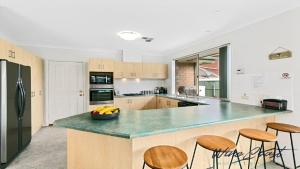 a kitchen with a large counter with stools in it at Sellicks Seacsape by Wine Coast Holidays in Sellicks Beach +15 photos