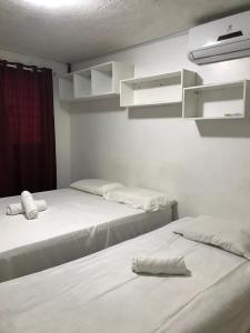 two beds sitting next to each other in a room at Linhares hospedagem in João Pessoa