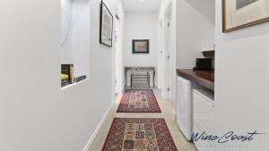 WillungaHideaway Nook by Wine Coast Holiday Rentals的一条带白色墙壁和地毯的走廊 更多13张照片