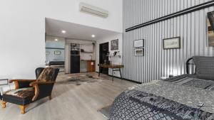 WillungaThe Cubby House by Wine Coast Holiday Rentals的一间带床和书桌的卧室和厨房