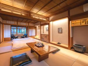 Machiya Hotel oyado baison في Mino: غرفة فيها سرير وطاولة فيها